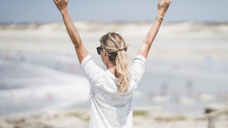 woman in white long sleeve shirt raising her hands
